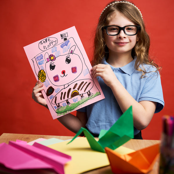 Child holding up drawing pn coloured activity card - Stationery superstore uk